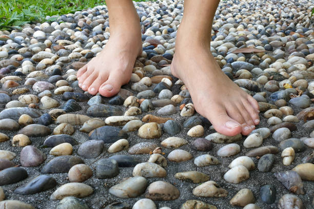 an image showing human feet on pebble floor