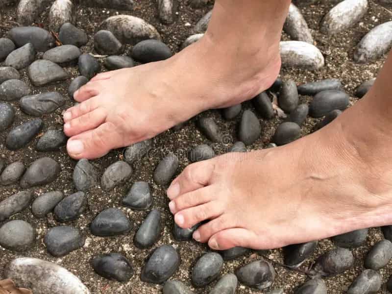 an image of feet on pebble floor