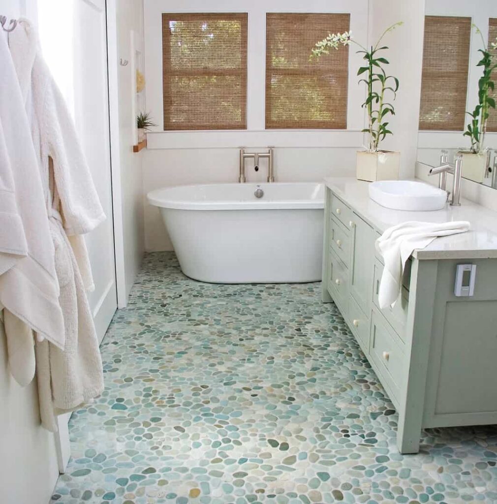 image of an interior of the bathroom with green and white pebbles on floor