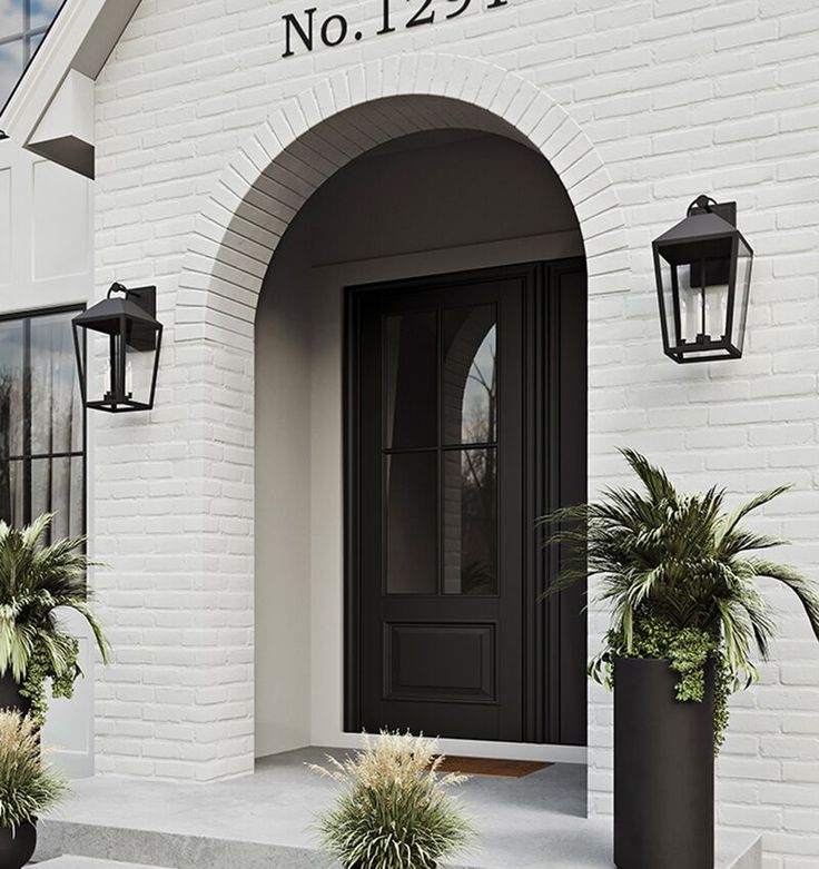 A white brick wall and a black door with light on each side