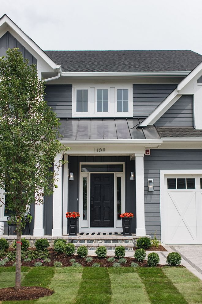 A black door with white trim window and plant outside the house