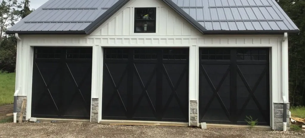 Black garage and white house and a small black glass window