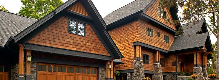 Black shingles and brick house and glass window and stone pillar