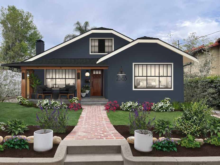 A White house and wooden front and black framed window and a stone pathway and flowers of each side