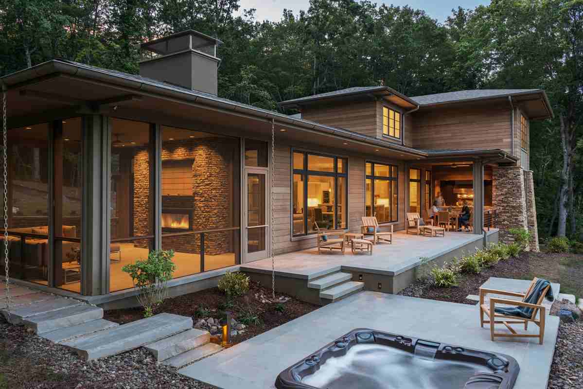 A wooden and stone house and chairs fronts of the house and black trim window and