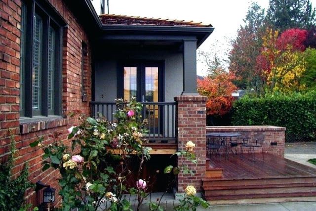 A brick house and black window flowers of the gate