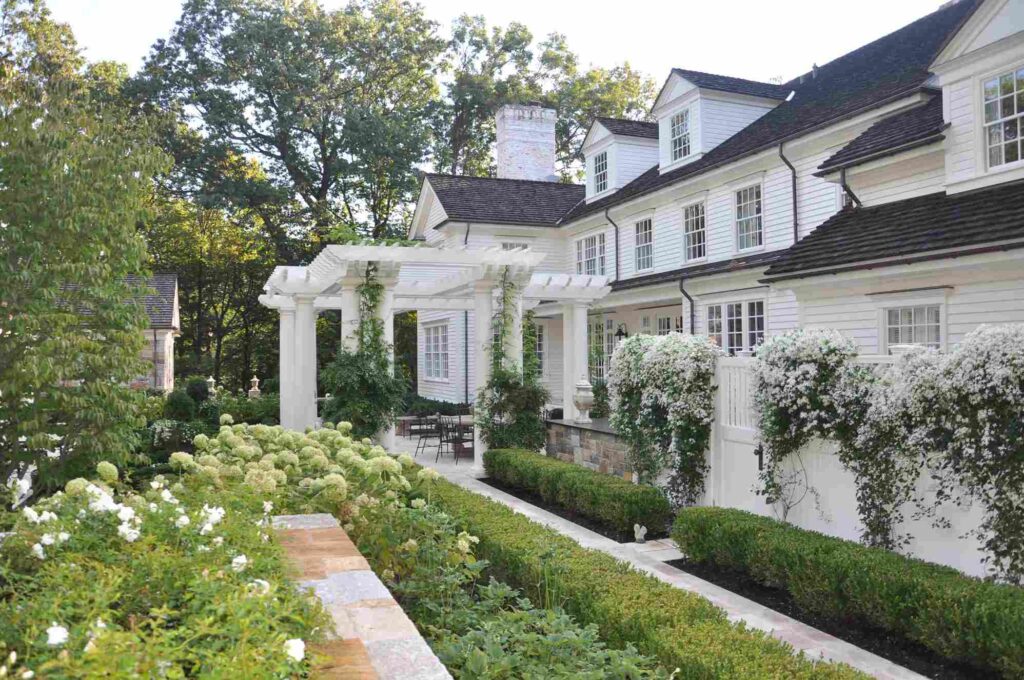 White landscaping house and black trim and garden outside of thr house