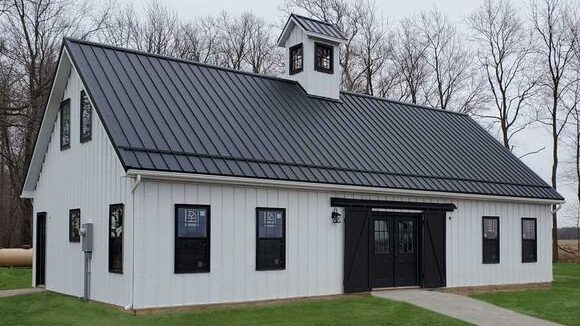 A white house with black overhang roof and black windows