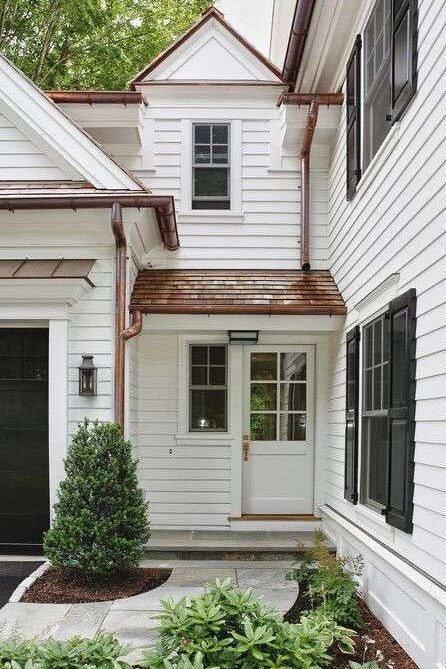 A white house with copper gutter and black window