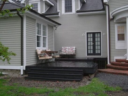 Black front porch on grey house and white trim and white framed windows