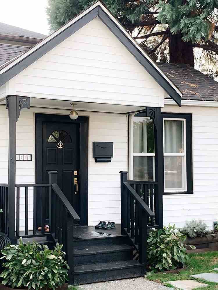 A black porch on white house with black stair and railing