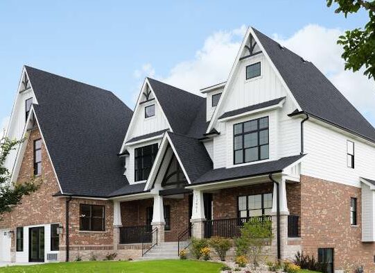 A white house with black roof and black gutter and trim windows