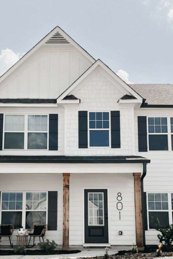 A house with black house number and black shutter and black glass front door