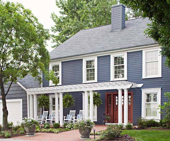 White pergola on blue house with white trim and red door