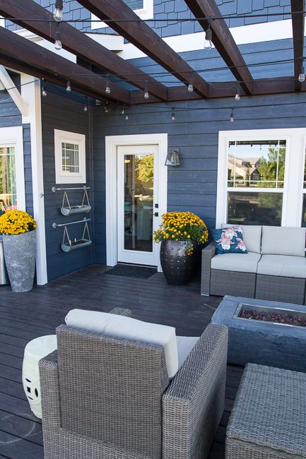 Blue house with black porch and flower vase on the floor