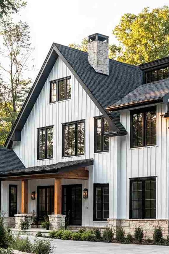 Black rake roof on white house and black windows and wooden pillars