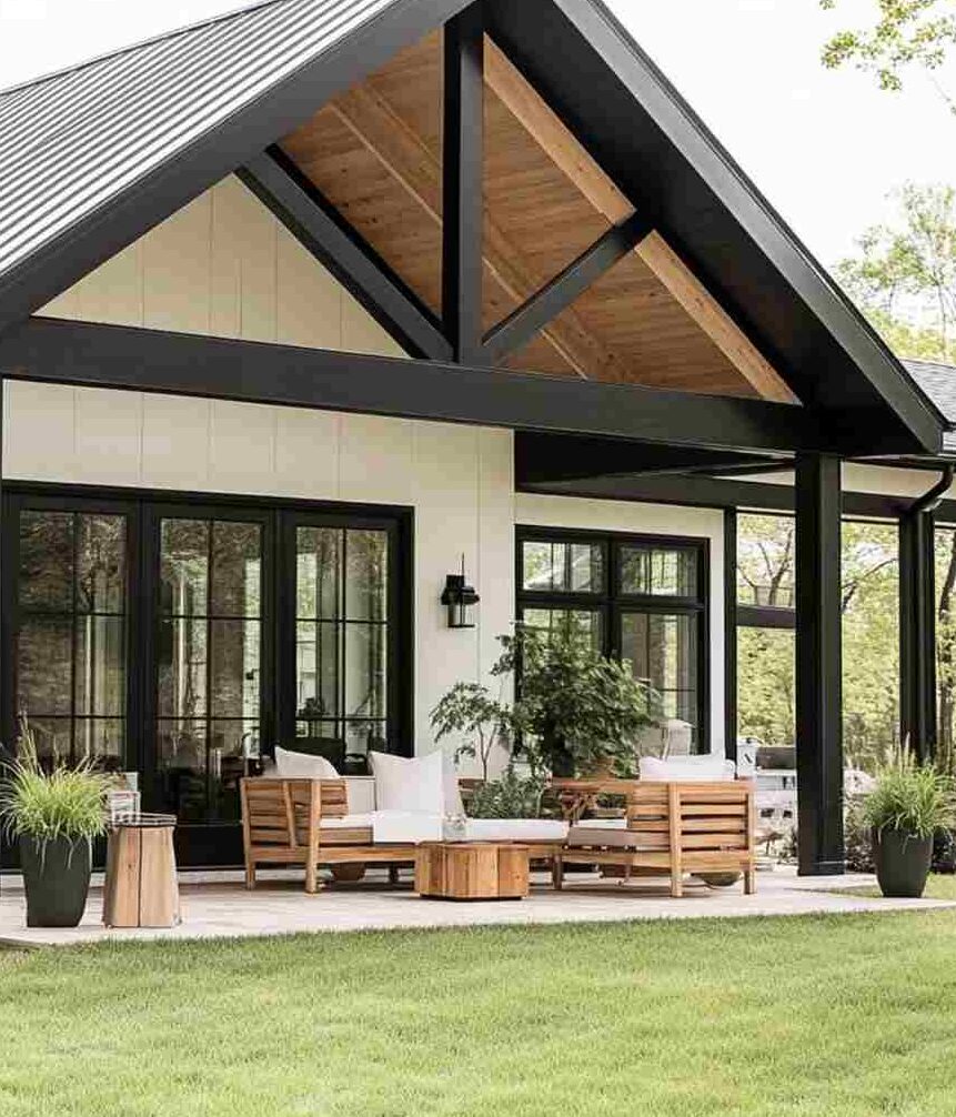 Black wood patio on white house and sofa and table outside of the house