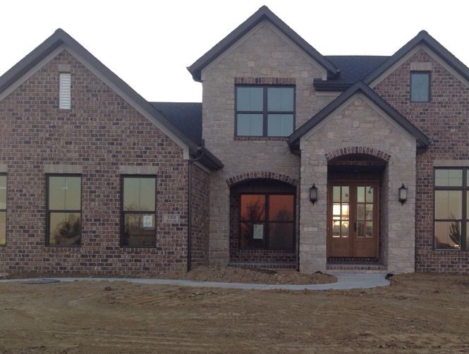 Brown brick house with black trim house and celling lights on wall