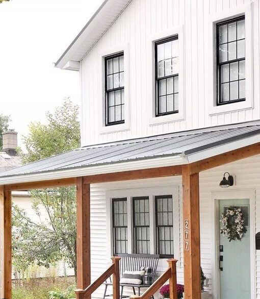 A white house with cedar column and black windows