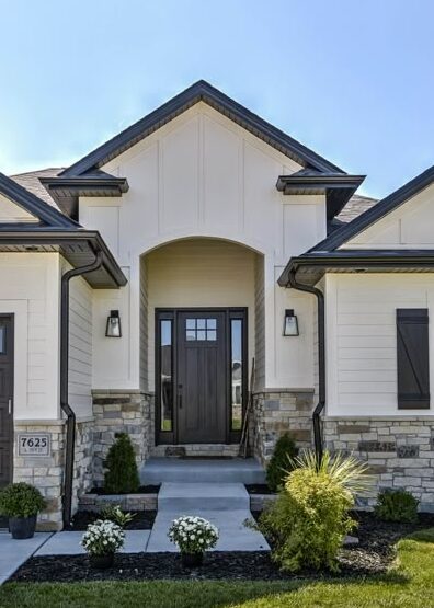 Black fascia on light tan house and lights on the wall