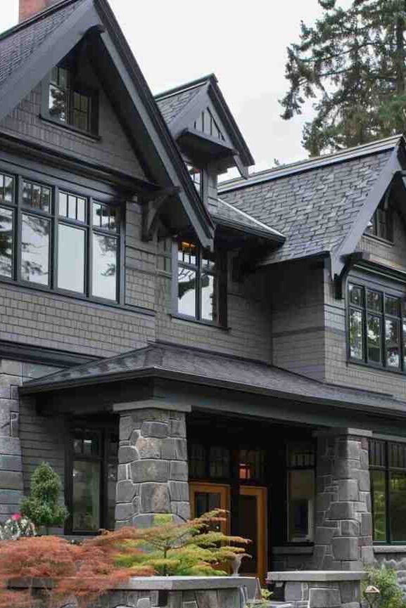 A grey house with with black trim and black framed windows