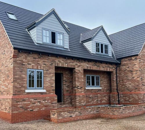 Charcoal metal cladding with grey trim and grey trim window