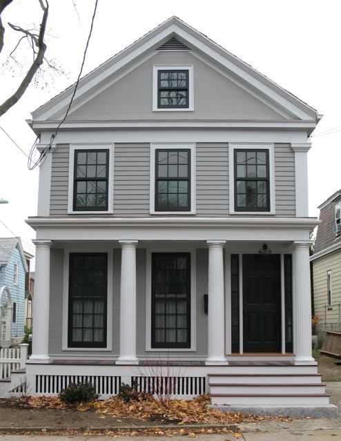 A light grey house with black windows and white pillar 