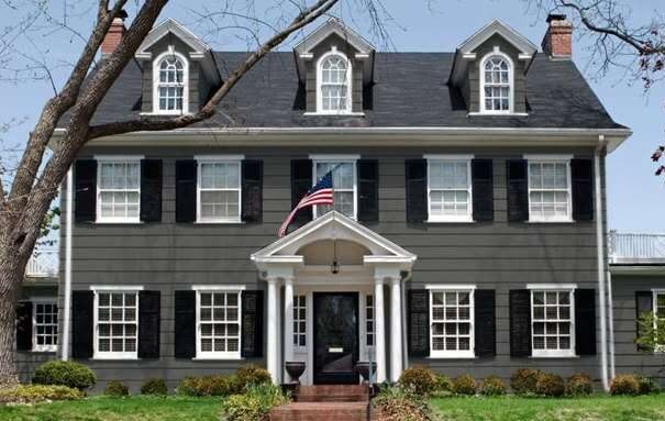 A grey house with black shutters and white trim 