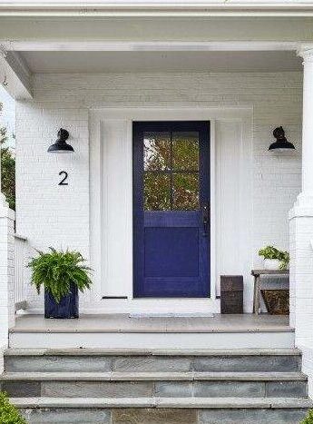 White house with blue door and celling lights on the wall