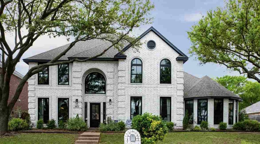 White house with black curved window and lights on the wall
