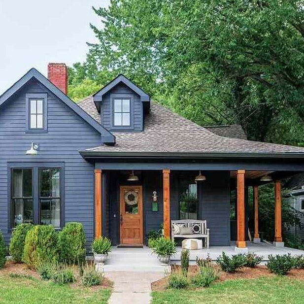 A blue house with wood accents and wooden door