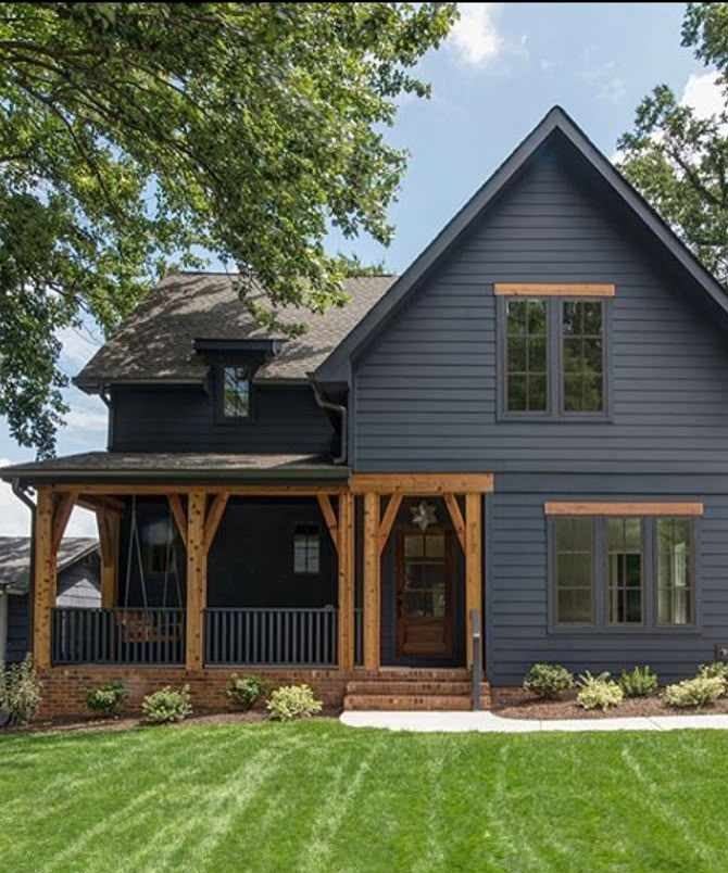 Blue siding with wooden porch beams and black glass windows