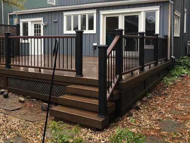 A blue house with black trim balcony and white trim