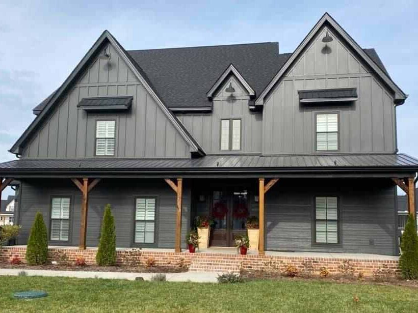 Grey house with overhang and wooden pillars 