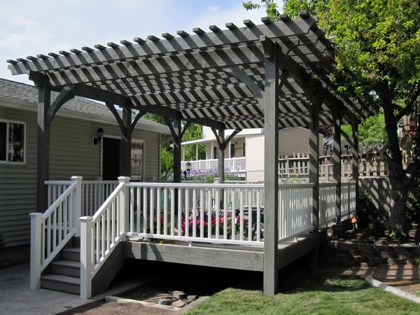 A grey house  with black pergola and white balcony  