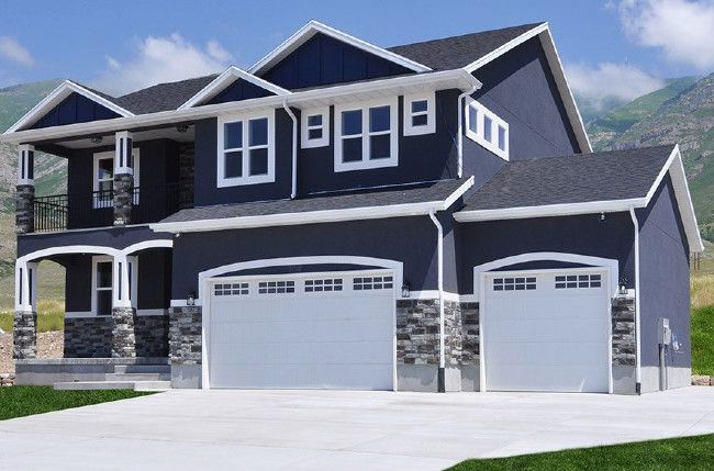 Dark navy blue stucco with black awnings and white trim