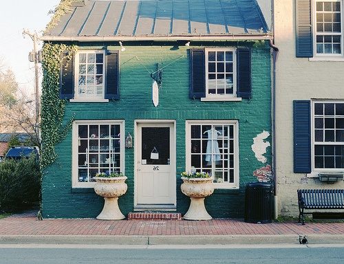Green-blue siding with white trim and black shutters and white trim windows