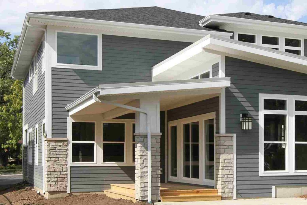 Light grey house with white gutters and and white framed windows 