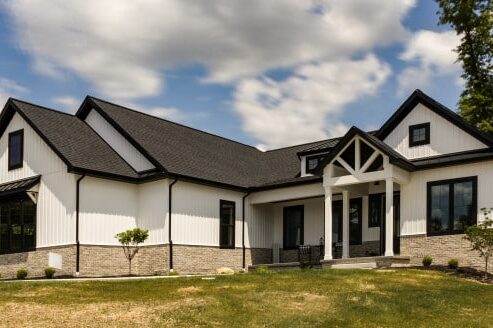 A white and black house with gable roof and black glass windows