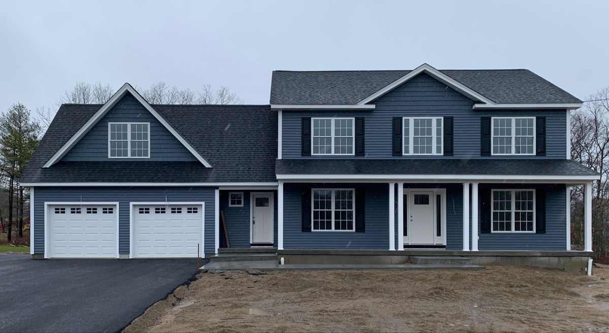 A blue house with white windows and black roof and black shutter