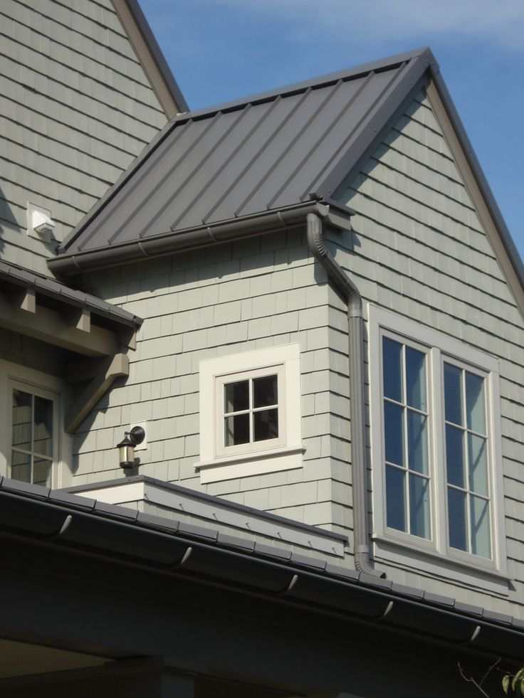 A grey house with dark grey shutter and downspouts