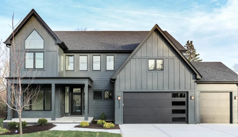 A light grey house with black front house with glass windows