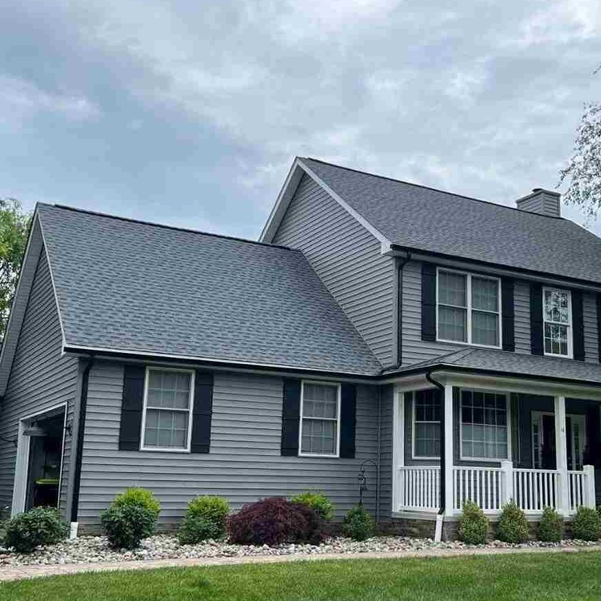 Light grey house with black trim and and gutters and white railing