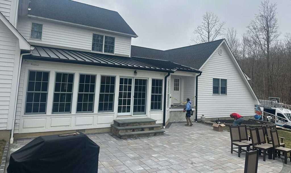 A white house with black roof and gutters and windows
