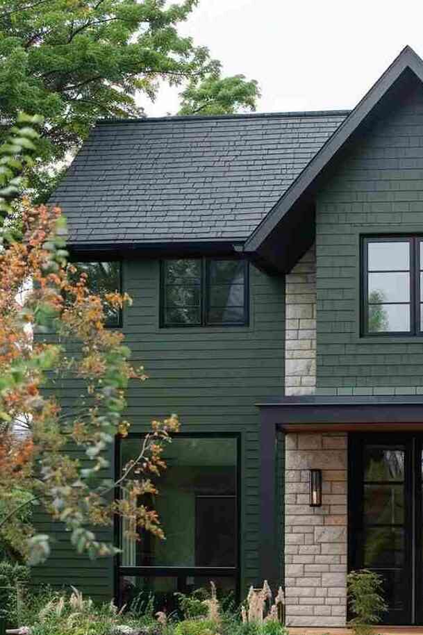 A dark green house with black windows 