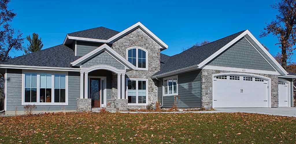 Natural stone element on light blue house and white trim windows