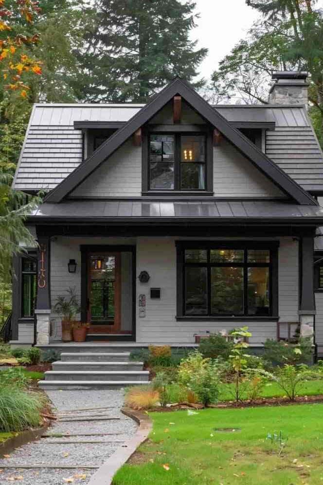 Black facade  with grey roof and trim and glass windows and garden outside of the house 