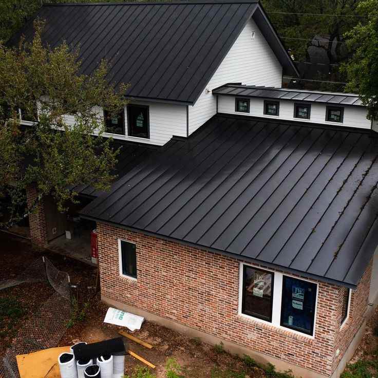 Red brick house with black tin and white framed windows