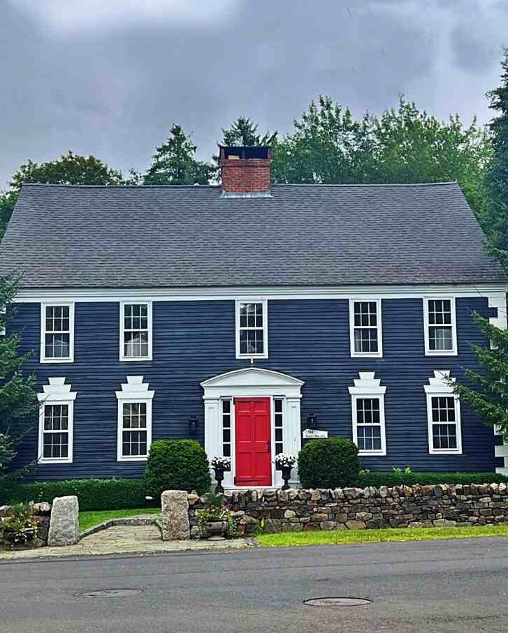 Red door and white trim windows on blue house