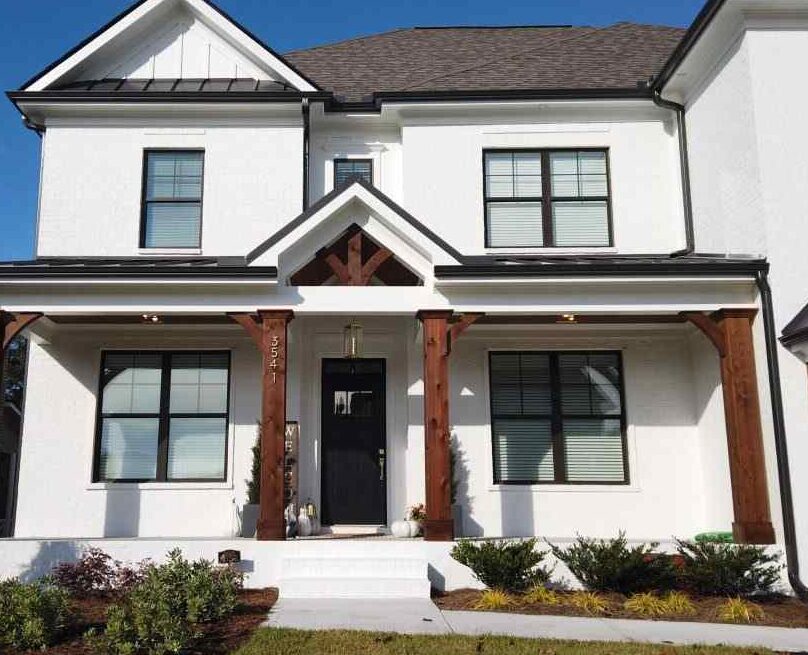 Small white house with black trim and wood accents